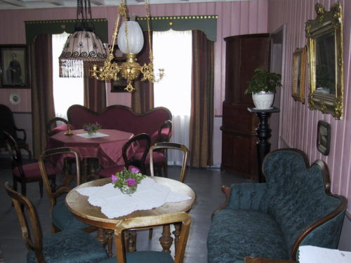 Stua på Hallvardmolåna med rosa tapet og historiske møbler